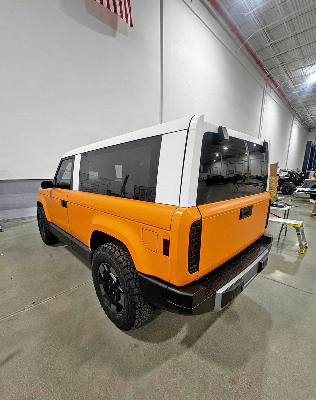 Slate Auto Pickup Truck Wrapped Orange Slate SUV and Pickup (with white roofs) inside Slate's pre-production facility Wrapped Slate SUV white roof 1
