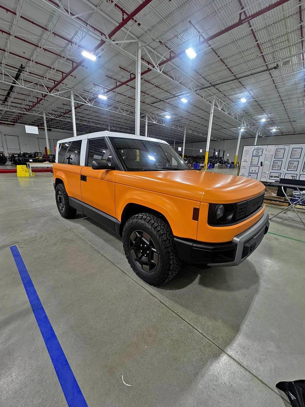 Slate Auto Pickup Truck Wrapped Orange Slate SUV and Pickup (with white roofs) inside Slate's pre-production facility Wrapped Slate SUV white roof 2