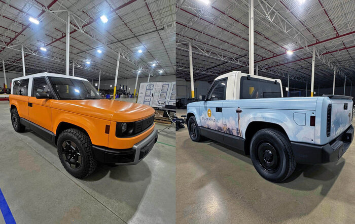 Wrapped Orange Slate SUV and Pickup (with white roofs) inside Slate's pre-production facility